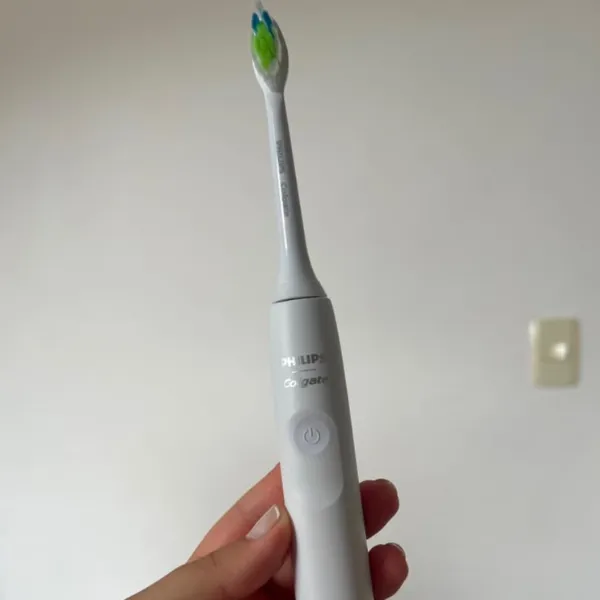 Escova elétrica Philips Colgate Sonic Pro 35 sendo segurada com uma mão