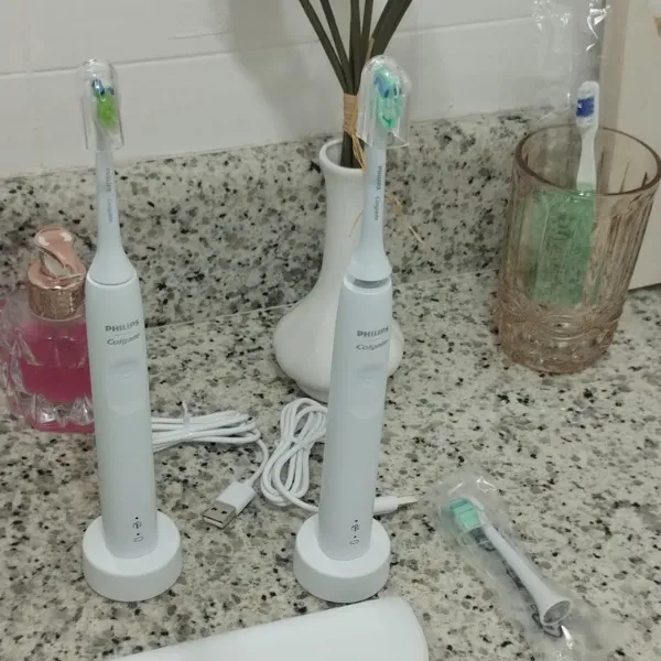 Duas escovas Colgate Sonic Pro 35 sobre pia com carregadores e refis ao lado