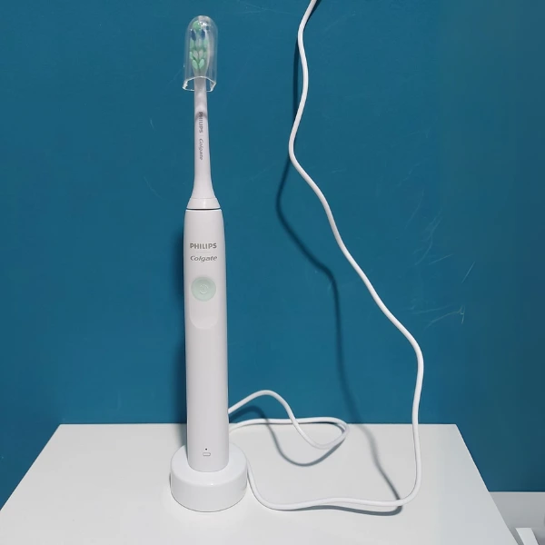 Escova Philips Colgate SonicPro 10 sobre base de carregamento com cabo conectado à tomada