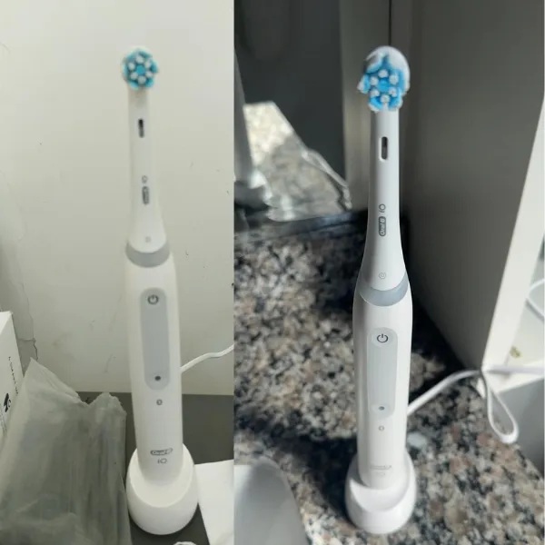 Escova Oral-B iO Series 4 sobre base de carregamento em bancada de banheiro com iluminação natural
