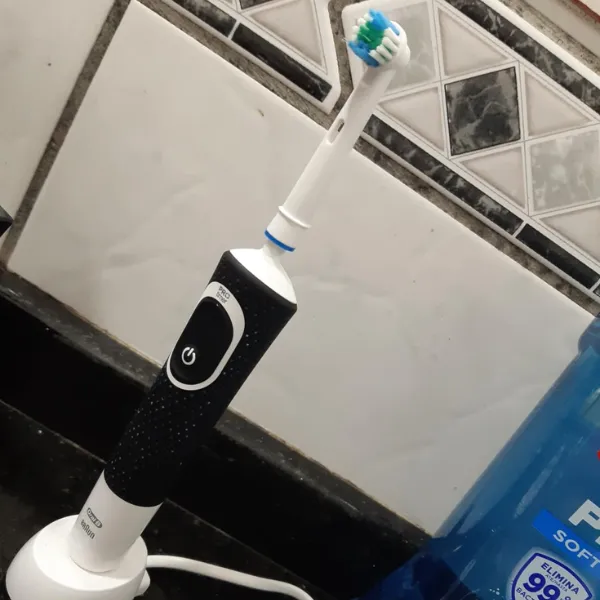 Escova Oral-B PRO Series 1+ posicionada na base de carregamento sobre a pia do banheiro