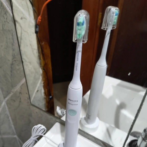 Escova elétrica Philips Colgate SonicPro 10 em frente ao espelho do banheiro sobre a pia